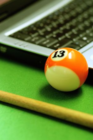 snooker balls and laptop on green surface, shallow depth of field