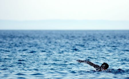 silhouette of a man swimming in the seaの写真素材