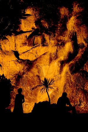 waterfall on a rocks, with people silhouettes, night shotの写真素材