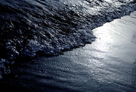 abstract shot of a water waves hitting a beachの写真素材