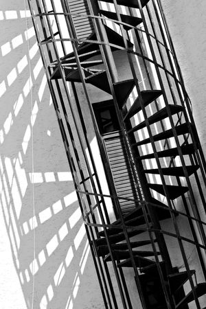 old spiral fire escape stairs, black and white photoの写真素材