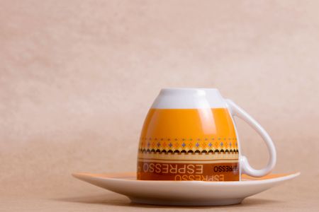 orange espresso cup on ochre backgroundの写真素材