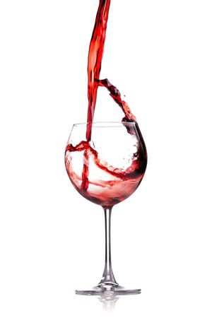 red wine splashing in a glass, isolated on whiteの写真素材