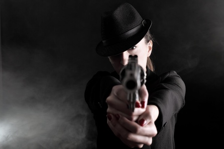 elegant lady in black holding a revolver の写真素材