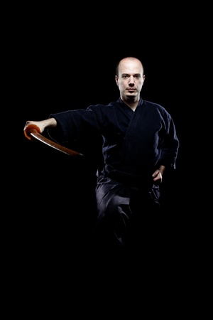 portrait of a kendo fighter with bokken, against black backgroungの写真素材