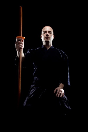 portrait of a kendo fighter with bokken, against black backgroungの写真素材