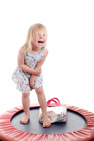 cute little girl having fun on a trampolineの写真素材