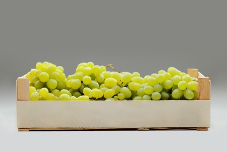 fresh green grapes in a wooden crateの写真素材