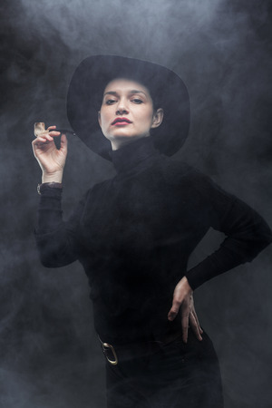girl in black holding a pipe on smoke backgroundの写真素材