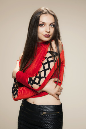 gothic style girl posing in studio wearing a red shirt and black short dressの写真素材