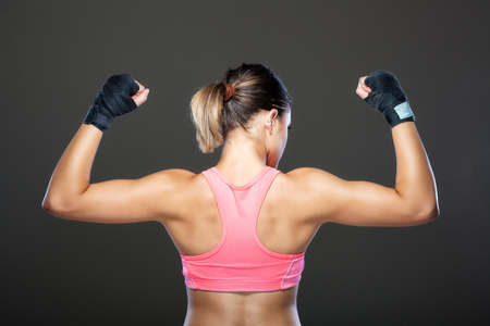 girl in pink outfit, showing musclesの写真素材