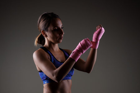 girl kickboxer putting on pink hand wrapsの写真素材