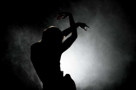 silhouette modern ballet dancer posing on dark background with smokeの写真素材