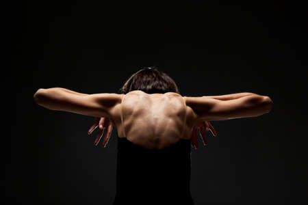 half silhouette modern ballet dancer posing on dark background with smokeの写真素材