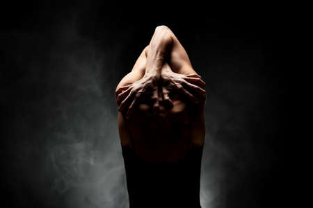 half silhouette modern ballet dancer posing on dark background with smokeの写真素材