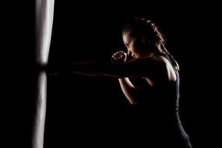 kick fighter girl punching a boxing bag