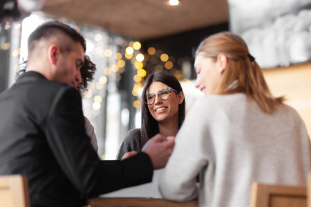 Young successful business people having a meeting at a cafe. Smiling and happy face expressions.の写真素材
