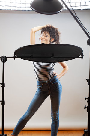 Beautiful brunette girl with long curly hair, posing in studio.の写真素材
