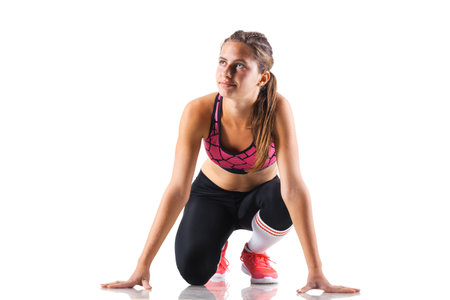 fit girl in race start position, isolated on white background