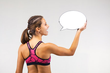fit girl holding an empty speech balloon, talkingの写真素材