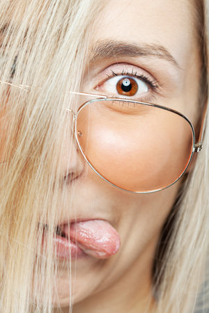Portrait of a woman with glasses and funny face expression.の写真素材