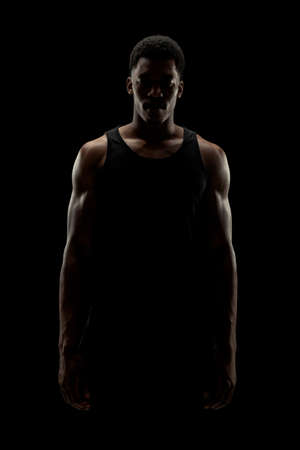Basketball player against black background. Serious concentrated african american man silhouette.の写真素材