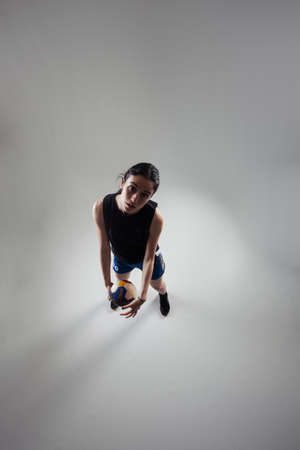 Handball player posing on light gray background. Girl posing with ball.の写真素材