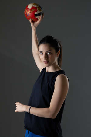 Handball player posing on dark gray background. Girl posing with ball.の写真素材