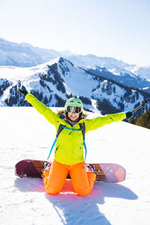 snowboarded girl posing on the snow with action cameraの写真素材