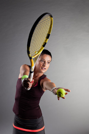 Professional female tennis player. Girl swinging racket.の写真素材