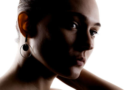 dark studio portrait of a beautiful young woman against white backgroung.の写真素材