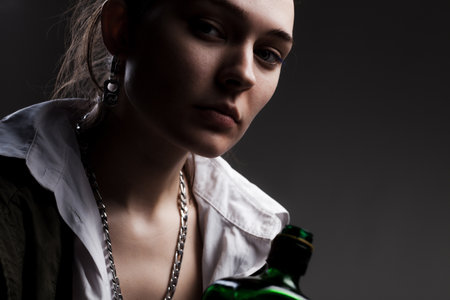 studio portrait of a beautiful girl holding alcohol bottle.の写真素材