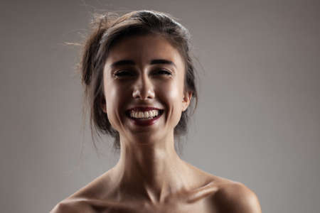 Beautiful brunette girl studio portrait. Smiling face expression.の写真素材