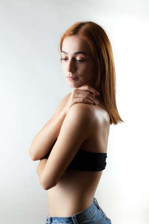 Beautiful girl with burnt orange hair posing in studio against gray background.の写真素材