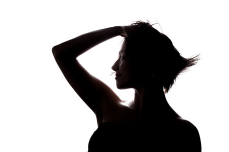 Silhouette portrait of a girl with short hair and hands up. Isolated against white backgroundの写真素材