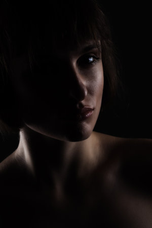 dark side lit beauty portrait of a lady with short hairの写真素材