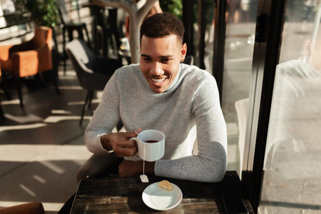 Friends in a restaurant talking smiling and drinking tea. Business colleagues having a meeting after work or during coffee break at a cafe bar.の写真素材