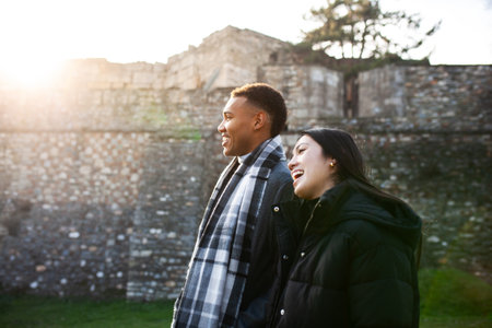 Man and woman walking in front of an old stone wall. Multiracial couple in love. Kale Fortress in Skopje, North Macedoniaの写真素材