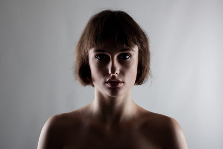 half silhouette portrait of a beautiful brunette girl with short hairの写真素材