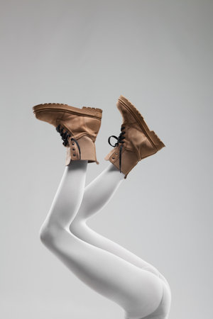 Sexy female legs with white leggings and waterproof boots.