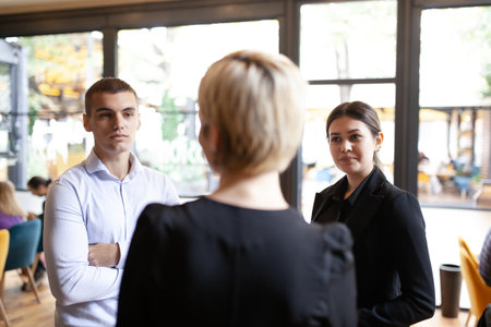 Three young business colleagues having a conversation. Successfull startup team brainstorming in a modern cafe.の写真素材