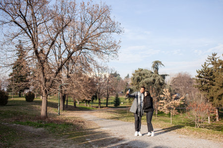 Man and woman posing in the park. Multiracial couple in love taking selfy photos.の写真素材