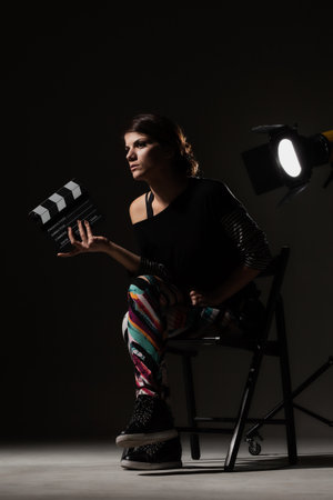 Female movie director. Girl holding clapperboard on set.の写真素材