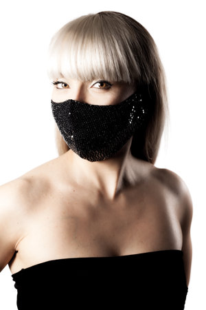 Beautiful brunette girl with blond hair fringe bangs wearing black fashionable protective face mask.の写真素材