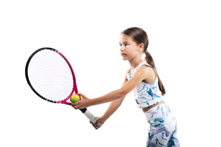 Young female tennis player. Little girl posing with racket and ball isolated on white background.の写真素材