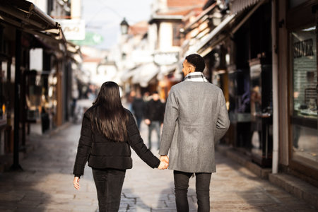 Multiracial couple posing on narrow streets in old part of the sity. Old turkish bazaar in Skopje, North Macedonia.の写真素材