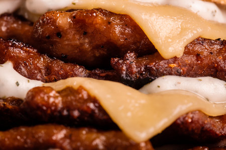 Abstract junk food. Quadruple burger with cheese cucumber and lettuce. Fast food background texture.の写真素材