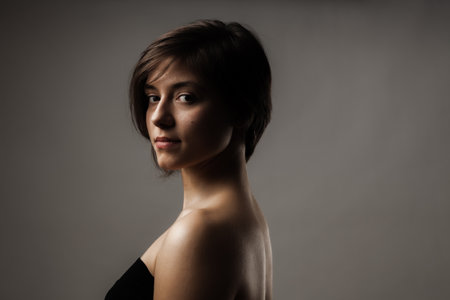 Close up portrait of a beautiful girl. Short hairstyle against gray background.の写真素材
