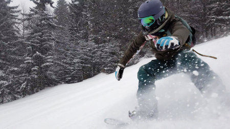 Girl snowboarding on slopes. Snow falling.の写真素材