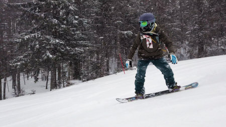 Girl snowboarding on slopes. Snow falling.の写真素材